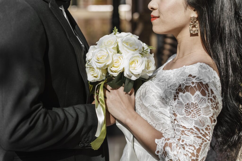 Mengungkap Harga Fotografer Wedding Jakarta dan Paket Pernikahan untuk Memastikan Momen Bahagiamu Terabadikan side view groom bride holding bouquet flowers